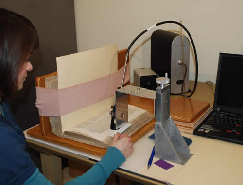 Woman analyzing a book leaf using the ASD UV-Vis-NIR spectrometer